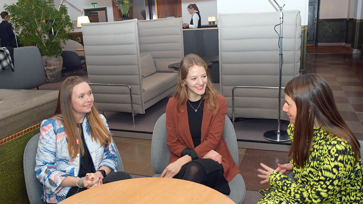 Tre unge omkring et rundt bord